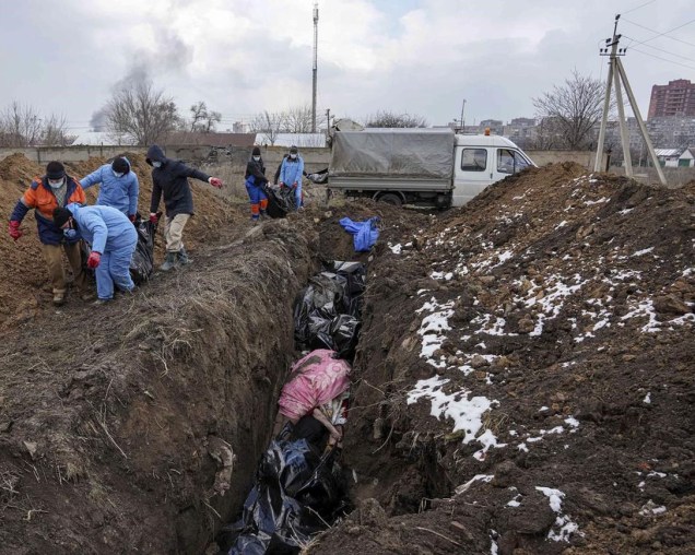 Corpos mortos são colocados em uma vala comum nos arredores de Mariupol, na Ucrânia -