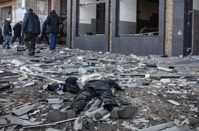 Um corpo de homem morto durante um bombardeio em uma rua ao lado de edifícios residenciais no distrito de Obolon, em Kiev -