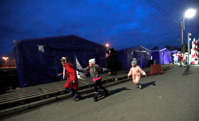 Crianças ucranianas brincam em frente às barracas de trânsito depois de passarem pela fronteira de Siret, no norte da Romênia -