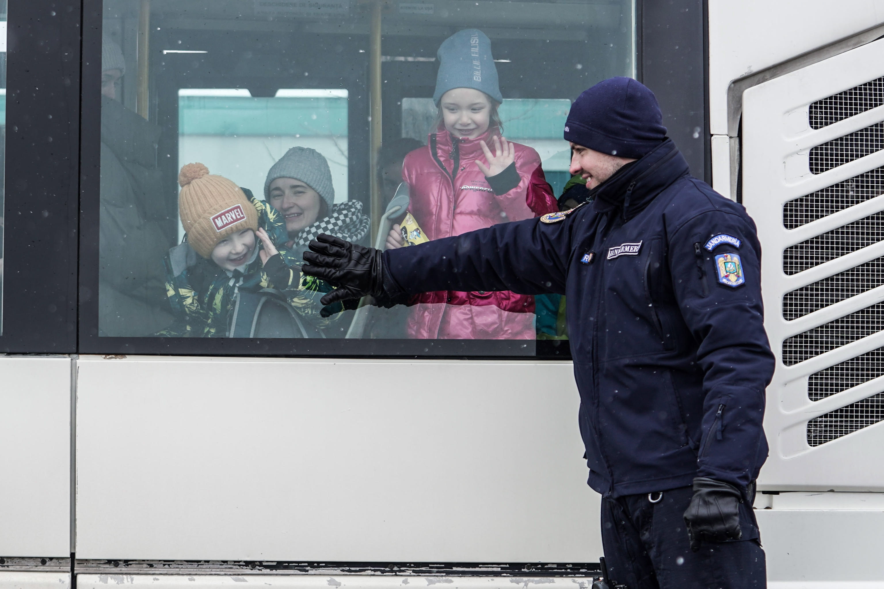 Siret (Rumania), 03/07/2022.- Un oficial de la gendarmería rumana sonríe a los refugiados ucranianos en un autobús en la frontera rumano-ucraniana en Siret, al norte de Rumania, el 07 de marzo de 2022. Desde que Rusia inició su operación militar en Ucrania el 7 de marzo de 2022. El 24 de febrero, unos 261.445 ciudadanos ucranianos entraron en Rumanía, según el último informe de la Policía de Fronteras.  (Rumanía, Rusia, Ucrania) EFE/EPA/Jessica Pasqualon