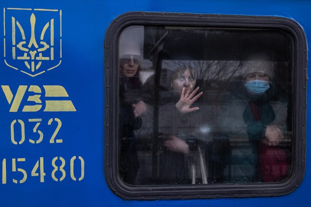 Mulheres olham de dentro de um trem de evacuação para a cidade de Kiev -