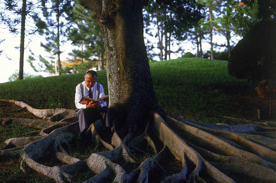 José Sarney sentado na raiz de uma árvore, lendo um livro, em 2006 -05/11/2006.cred. Orlando Brito