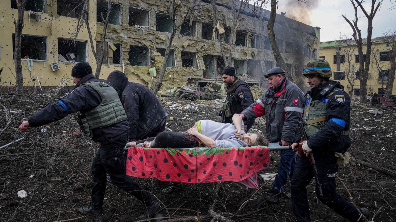 Ukrainian emergency employees and volunteers carry an injured pregnant woman from the damaged by shelling maternity hospital in Mariupol, Ukraine, Wednesday, March 9, 2022. A Russian attack has severely damaged a maternity hospital in the besieged port city of Mariupol, Ukrainian officials say. (AP Photo/Evgeniy Maloletka)