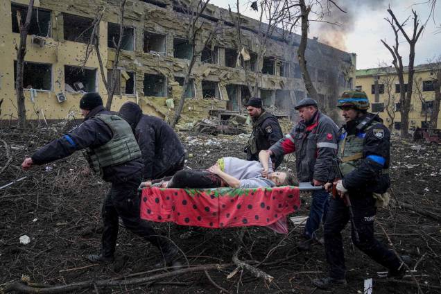 Funcionários e voluntários de emergência ucranianos carregam uma mulher grávida ferida da maternidade danificada pelo bombardeio em Mariupol, na Ucrânia - Funcionários e voluntários de emergência ucranianos carregam uma mulher grávida ferida da maternidade danificada pelo bombardeio em Mariupol, na Ucrânia -
