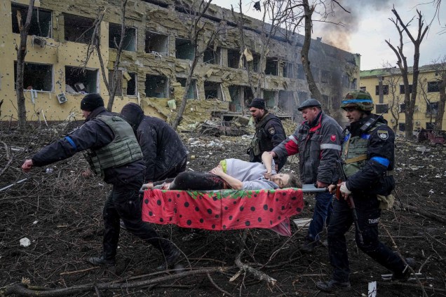 Funcionários e voluntários de emergência ucranianos carregam uma mulher grávida ferida da maternidade danificada pelo bombardeio em Mariupol, na Ucrânia -