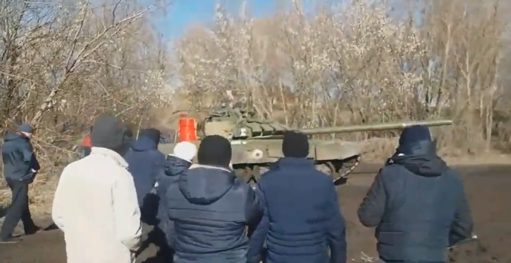 Uma multidão de pessoas comuns se posiciona em frente a um tanque russo, que decide recuar -
