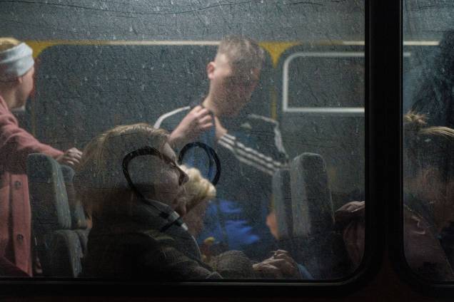 Passageiros aguardam enquanto um comboio de 30 ônibus transportando refugiados de Mariupol e Melitopol chega ao centro de registro em Zaporizhzhia -