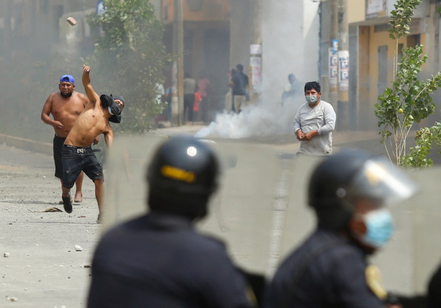 Manifestantes entram em confronto com a tropa de choque durante uma greve parcial de transportadores de carga e passageiros, em Ate, distrito a leste de Lima -