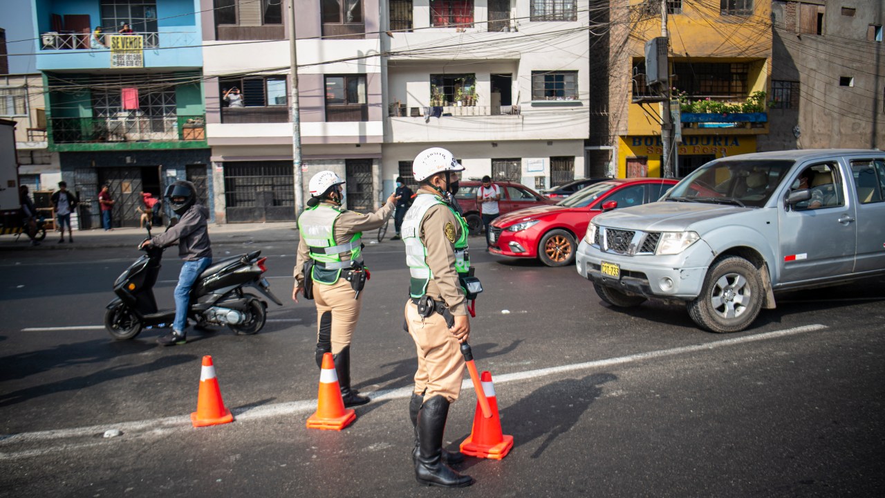 Policiais param veículos em posto de controle após início de toque de recolher em Lima, Peru. 05/04/2022
