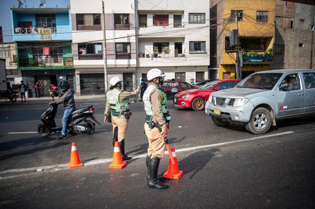 Policiais param veículos em posto de controle após início de toque de recolher em Lima, Peru. 05/04/2022