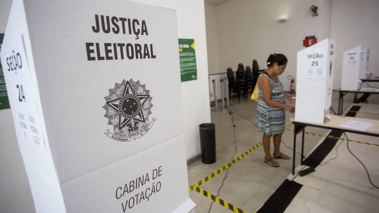 (FILES) In this file photo taken on October 28, 2018 A Brazilian woman votes at a polling station during the second round of the presidential elections, in Rio de Janeiro, Brazil. - A UN rapporteur warned on April 8, 2022 that political violence is "destroying democracy" in Brazil and urged authorities to take measures to guarantee a safe environment during the October elections. (Photo by DANIEL RAMALHO / AFP)