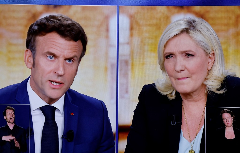 A picture shows screens displaying a live televised debate between French President and La Republique en Marche (LREM) party candidate for re-election Emmanuel Macron (L) and French far-right party Rassemblement National (RN) presidential candidate Marine Le Pen (R), broadcasted on French TV channels TF1 and France 2, in a viewing roon at the studios hosting the debate in Saint-Denis, north of Paris, ahead of the second round of France's presidential election. - French voters head to the polls for a run-off vote between Macron and Le Pen on April 24, 2022. (Photo by Ludovic MARIN / AFP)