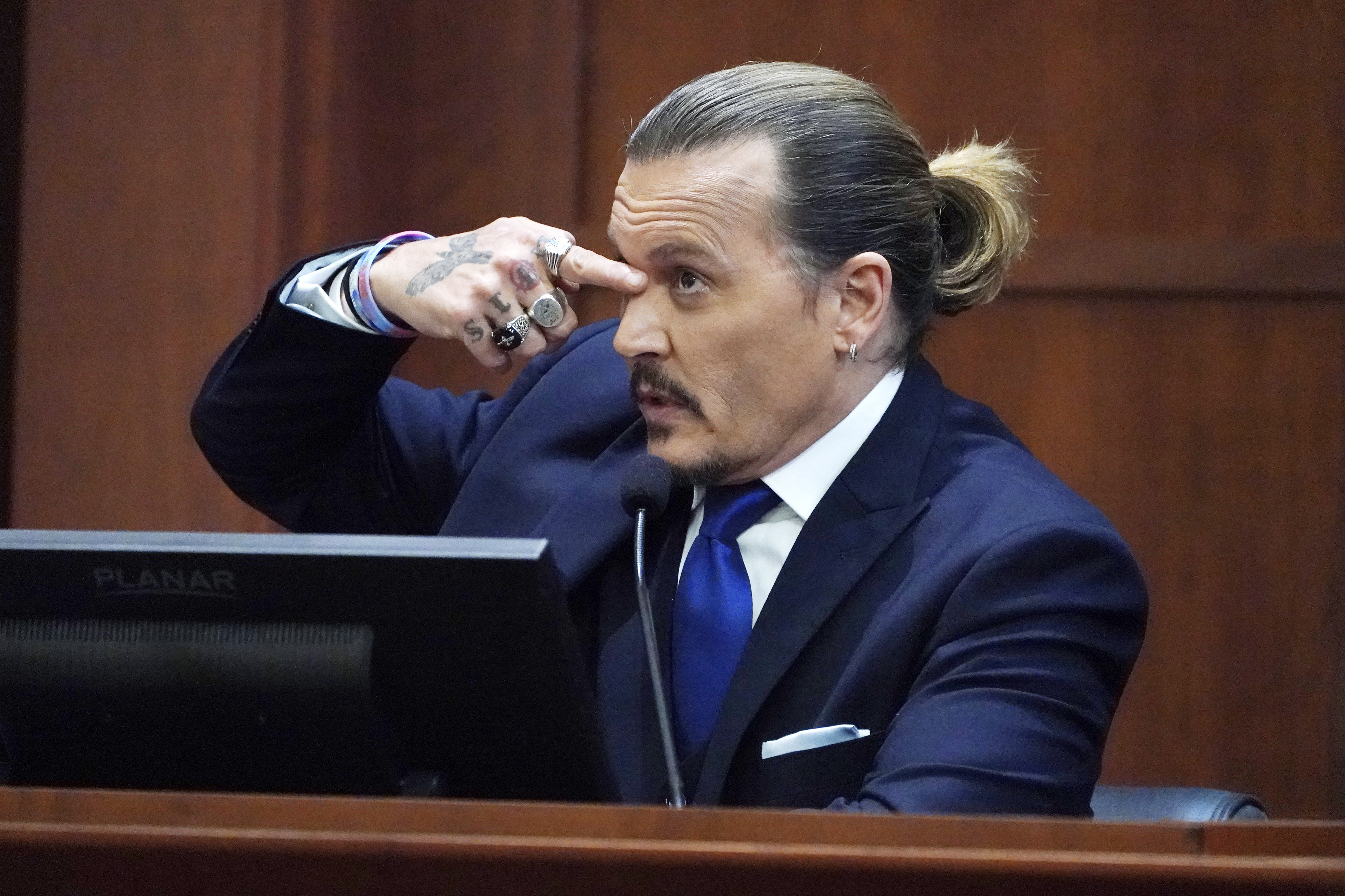 Actor Johnny Depp testifies that a can of mineral spirits actress Amber Heard through, hit him there, in the courtroom at the Fairfax County Circuit Courthouse in Fairfax, Virginia, April 25, 2022. - Actor Johnny Depp sued his ex-wife Amber Heard for libel in Fairfax County Circuit Court after she wrote an op-ed piece in The Washington Post in 2018 referring to herself as a "public figure representing domestic abuse." (Photo by Steve Helber / POOL / AFP)
