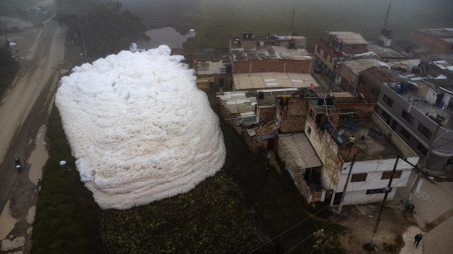 Vista aérea mostra espuma pungente que se formou em um rio poluído e invadiu o bairro de Los Puentes, em Mosquera, a oeste de Bogotá, em 26 de abril de 2022.