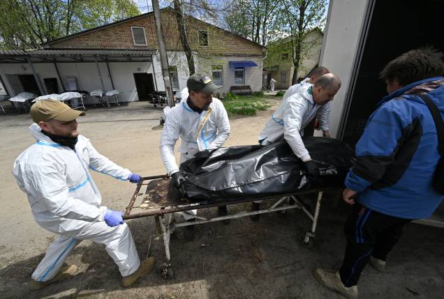 EDITORS NOTE: Graphic content / Mortuary workers unload a bag containing a body of a victim in Bucha, northwest of Kyiv, on April 28, 2022, amid Russian invasion of Ukraine. (Photo by Genya SAVILOV / AFP)