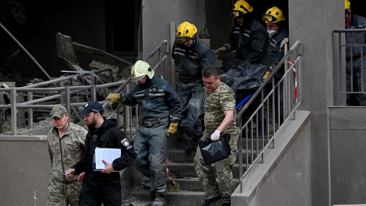 Equipes de resgate carregam um corpo de um prédio danificado após ataques russos em Kiev em 29 de abril de 2022, em meio à invasão russa da Ucrânia. - Ataques russos atingiram Kiev em 28 de abril, à noite, quando o secretário-geral da ONU, Antonio Guterres, estava visitando. (Foto de Sergei SUPINSKY/AFP)