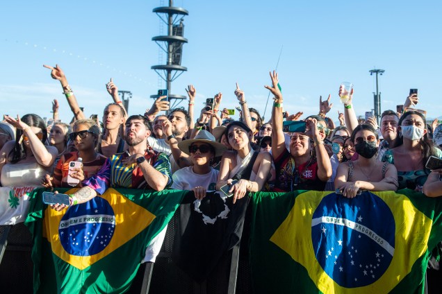 Fãs seguram bandeiras brasileiras, enquanto a cantora brasileira Anitta se apresenta durante o Coachella Valley Music and Arts Festival em Indio, Califórnia, em 15 de abril de 2022.