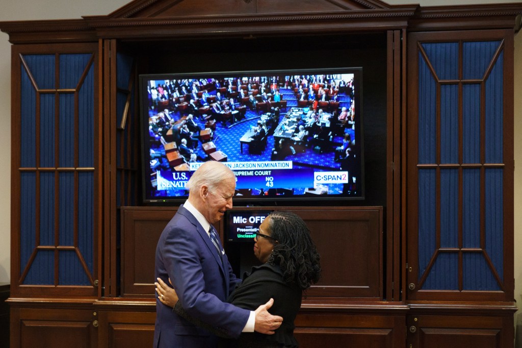 US President Joe Biden embraces Judge Ketanji Brown Jackson as they watch the Senate vote on her nomination to be an associate justice on the US Supreme Court, from the Roosevelt Room of the White House in Washington, DC on April 7, 2022. (Photo by MANDEL NGAN / AFP)
