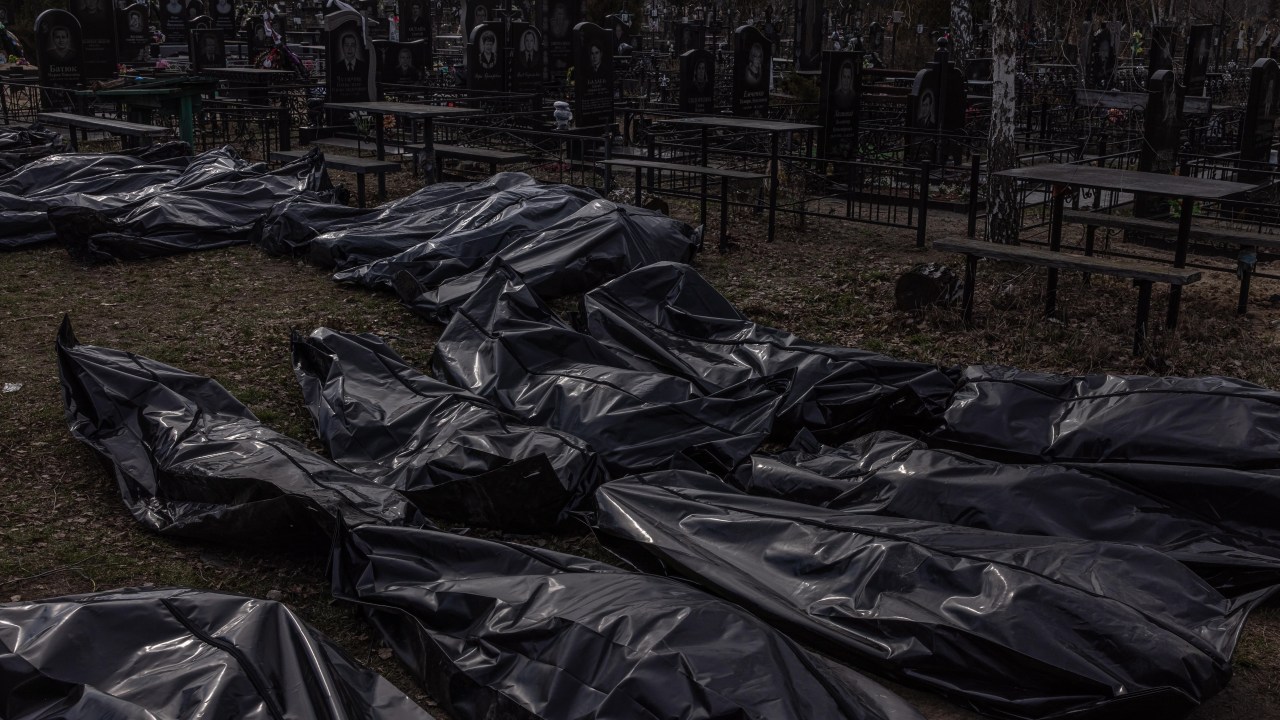 Bucha (Ucrânia), 07/04/2022.- Corpos de mortos, que foram levados ao cemitério, jaziam no chão em sacos para cadáveres, em Bucha, noroeste de Kiev, Ucrânia, 07 de abril de 2022. Centenas de torturados e mortos civis foram encontrados em Bucha e em outras partes da região de Kiev depois que o exército russo se retirou dessas áreas. As evidências crescentes mostram que se acredita que as forças russas estão por trás das atrocidades quando controlavam as áreas. As tropas russas entraram na Ucrânia em 24 de fevereiro, resultando em combates e destruição no país e desencadeando uma série de severas sanções econômicas à Rússia por parte dos países ocidentais. (Rússia, Ucrânia) EFE/EPA/ROMAN PILIPEY