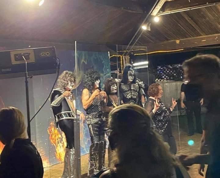 Kiss posa para fotos com fãs separado por um biombo de acrílico