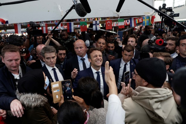 O presidente francês Emmanuel Macron com moradores, durante uma caminhada na praça do mercado Saint-Christophe em Cergy, subúrbio de Paris, França, 27 de abril de 2022.