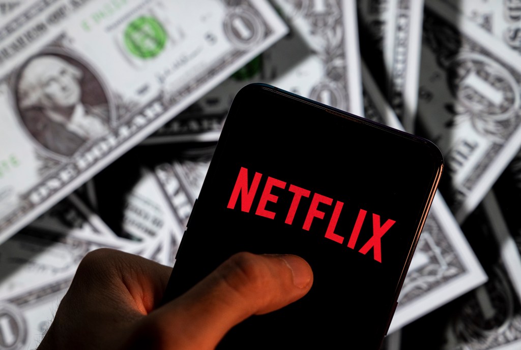 CHINA - 2021/04/23: In this photo illustration, a Netflix logo seen displayed on a smartphone with USD (United States dollar) currency in the background. (Photo Illustration by Budrul Chukrut/SOPA Images/LightRocket via Getty Images)