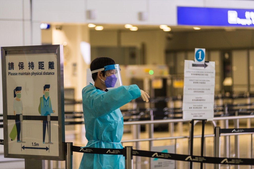 Hong Kong, China, 2 Apr 2022, Airport staff signal arriving passengers to place them in the appropriate queue for the quarantine hotel coach in Hong Kong In Hong Kong International Airport. (Photo by Marc Fernandes/NurPhoto via Getty Images)