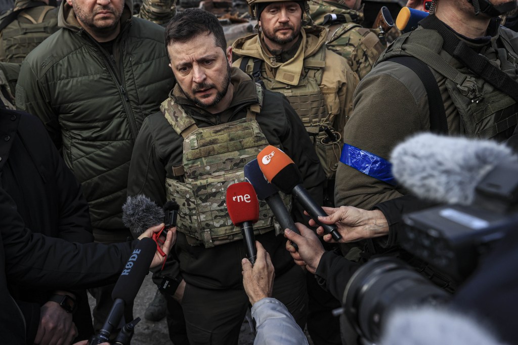 BUCHA, KYIV PROVINCE, UKRAINE, APRIL 04: Ukrainian President Volodymyr Zelenskyy accompanied by Ukrainian soldiers speaks to press during his visit at the town of Bucha, after it was liberated from Russian Army, in Bucha, Ukraine on April 04, 2022. (Photo by Metin Aktas/Anadolu Agency via Getty Images)