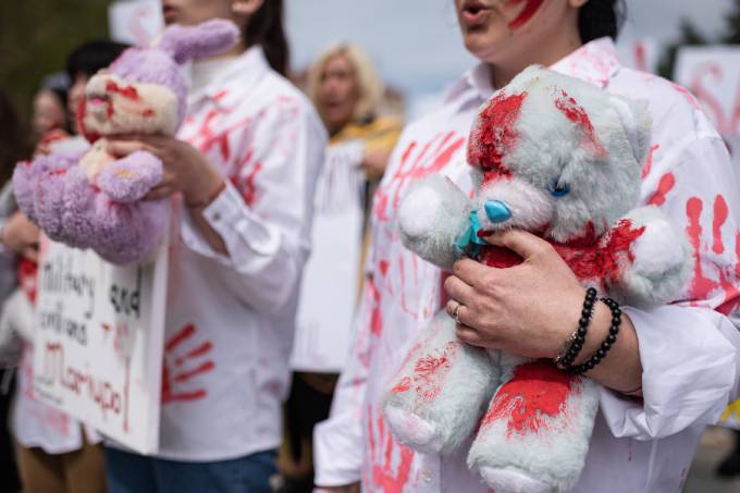 A young woman attending a demonstration in support of Mariupol holds a soft toy covered with red paint, on April 27, 2022 in Kyiv, Ukraine