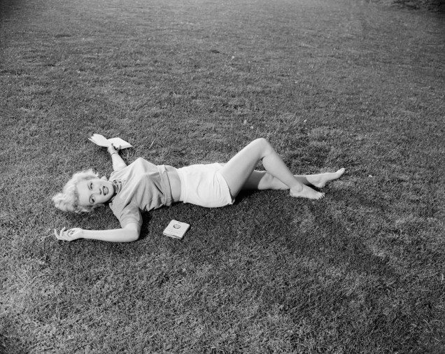 Marilyn Monroe deitada no gramado de sua casa de campo, em 1951 -