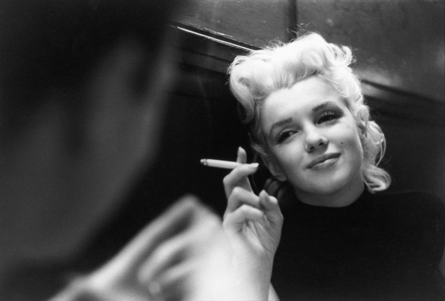 A atriz Marilyn Monroe fuma um cigarro em um restaurante, em 1955, na cidade de Nova York -
