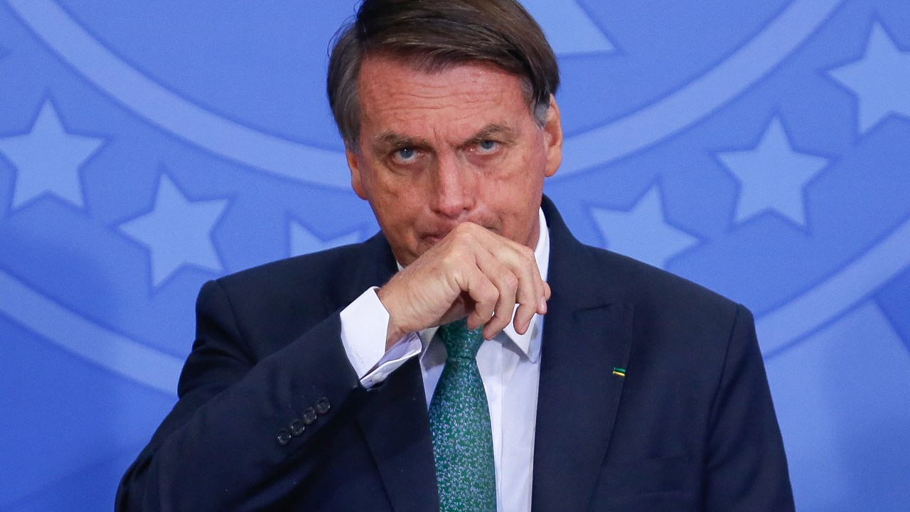FILES) In this file photo taken on January 28, 2022, Brazilian President Jair Bolsonaro gestures during the launching of a national program to provide voluntary civil service at Planalto Palace in Brasilia. - Brazilian President Jair Bolsonaro was admitted to a military hospital in Brasilia late on March 28, 2022, to undergo tests after feeling unwell, local press reported. (Photo by Sergio Lima / AFP)