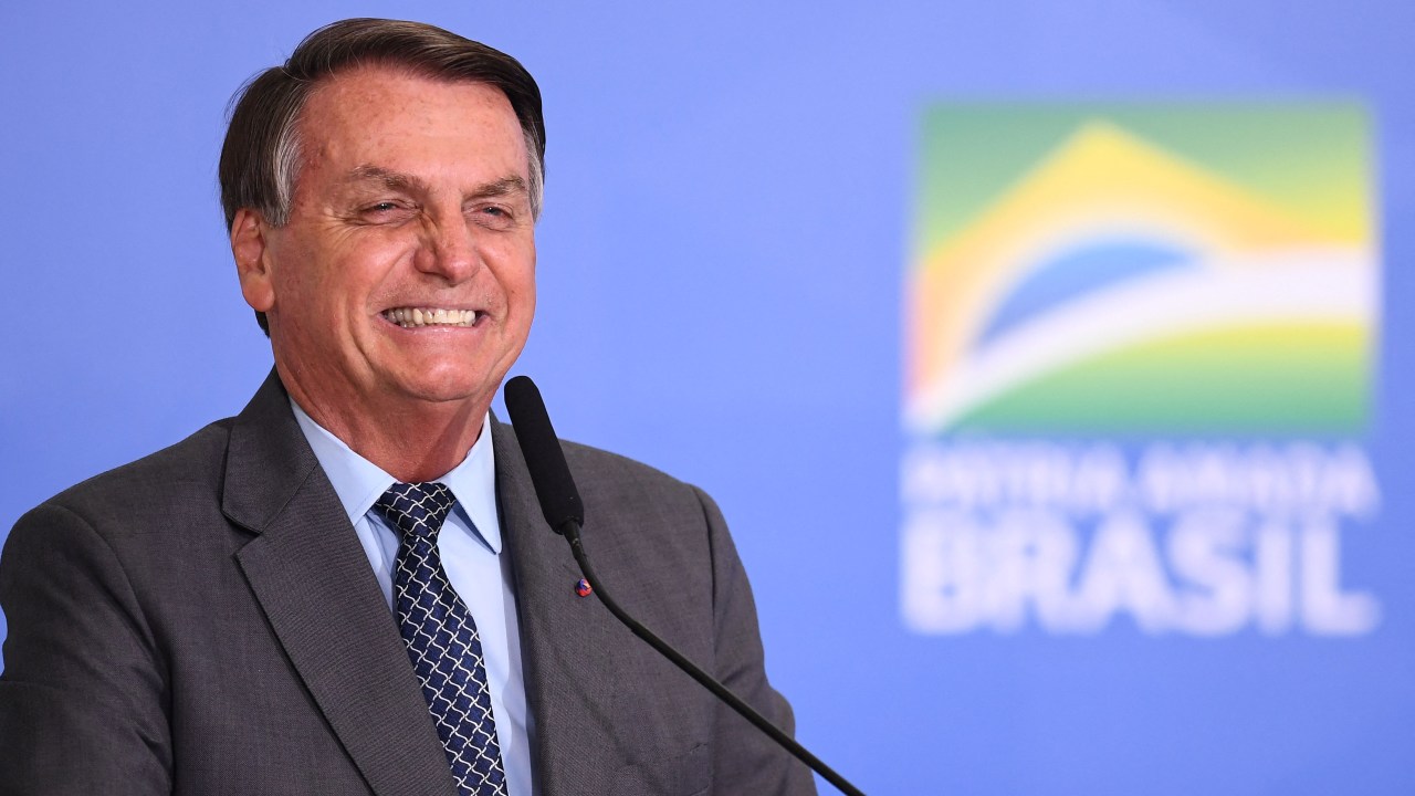 Brazilian President Jair Bolsonaro gestures during the launch of the Gigantes do Asfalto Program, which aims to reduce bureaucracy for cargo trucking, at Planalto Palace in Brasilia, on May 18, 2021. (Photo by EVARISTO SA / AFP)