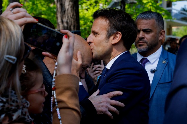 Emmanuel Macron beija a cabeça de um apoiador , próximo`a estação Le Touquet, em Paris. 
