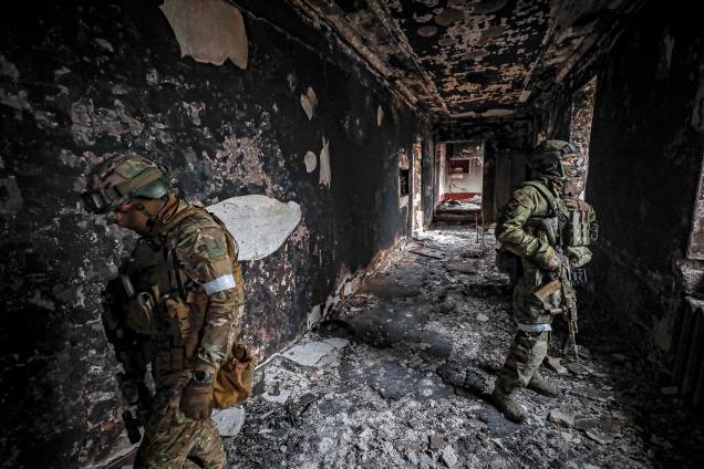 Soldados russos em escombros de prédio em Mariupol, Ucrânia, 12 de abril de 2022.