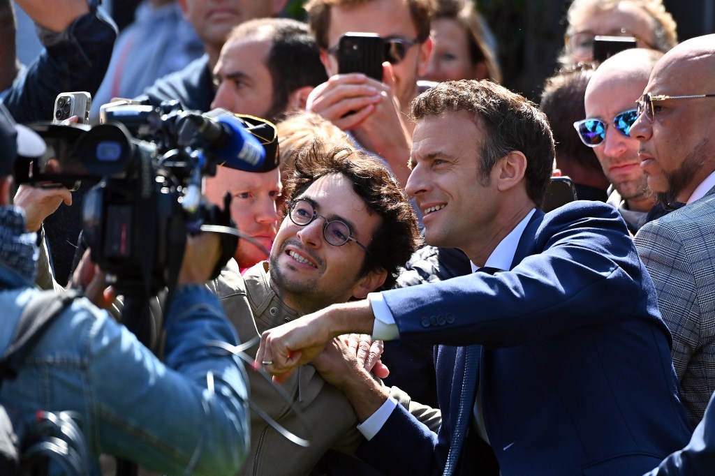 Emmanuel Macron, presidente da França, posa com apoiadores após votar na eleição presidencial neste domingo, 24