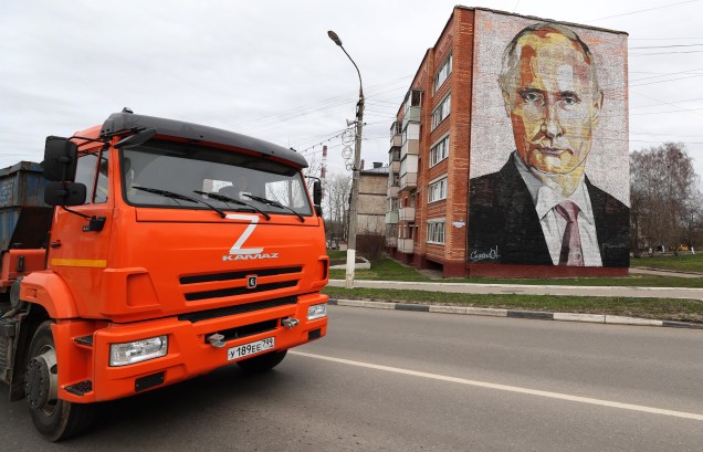 Um caminhão com a letra Z, percorre uma rua em frente a um bloco de apartamentos com um mural representando o presidente russo Vladimir Putin na cidade de Kashira, Rússia, 20 de abril de 2022.