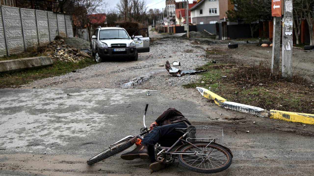 EDITORS NOTE: Graphic content / A dead body lies on the ground in a street in Bucha, northwest of Kyiv, as Ukraine says Russian forces are making a "rapid retreat" from northern areas around Kyiv and the city of Chernigiv, on April 2, 2022. - The bodies of at least 20 men in civilian clothes were found lying in a single street Saturday after Ukrainian forces retook the town of Bucha near Kyiv from Russian troops, AFP journalists said. Russian forces withdrew from several towns near Kyiv in recent days after Moscow's bid to encircle the capital failed, with Ukraine declaring that Bucha had been "liberated". (Photo by RONALDO SCHEMIDT / AFP)