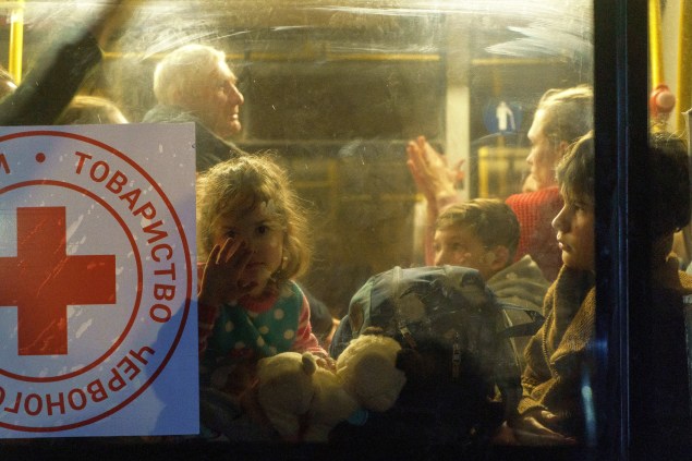 Uma criança olha pela janela de um ônibus enquanto um comboio de 30 ônibus transportando refugiados de Mariupol e Melitopol chega ao centro de Zaporizhzhia -