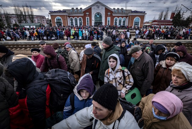 Famílias caminham em uma plataforma para embarcar em um trem na estação central de Kramatorsk -
