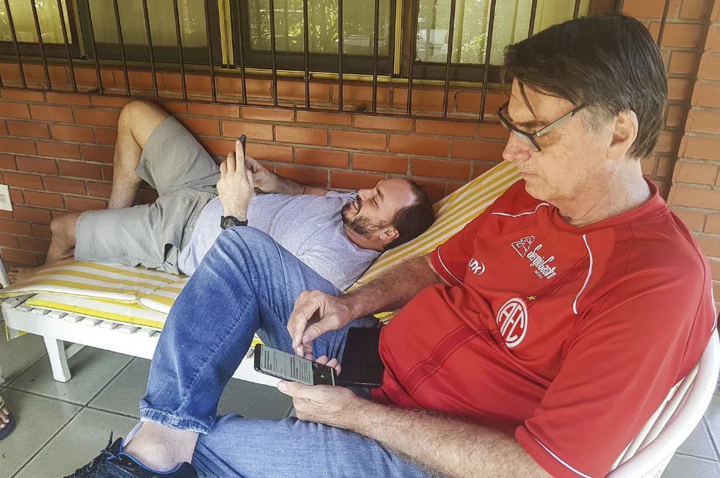 Bolsonaro e o filho, Carlos, no celular -