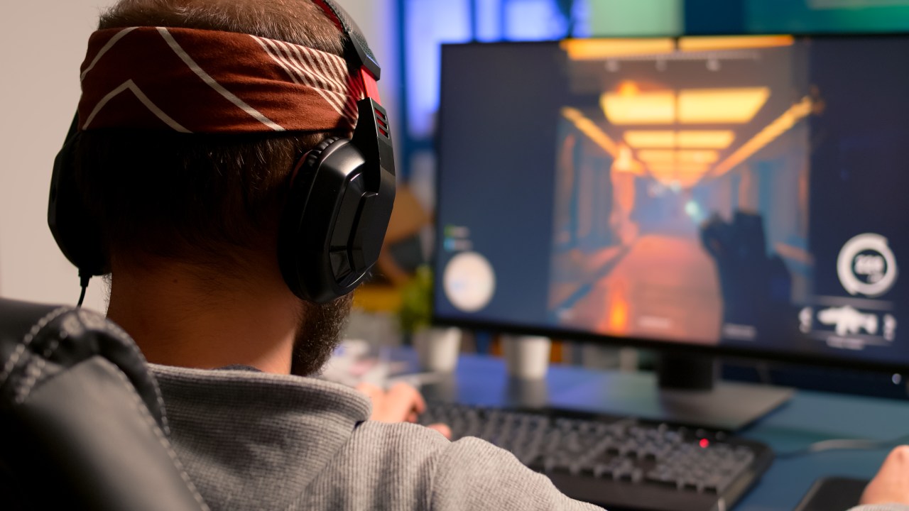 Rapaz se diverte com jogo eletrônico em uma tela de computador