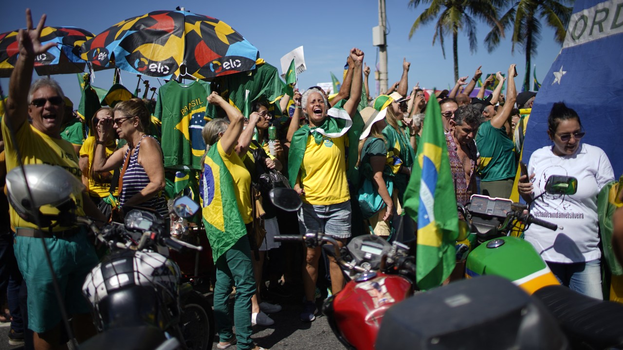 Supporters of Brazilian President Jair Bolsonaro demonstrate to shows their support for the president and his controversial ally, deputy Daniel Silveira, who Bolsonaro pardoned after the Supreme Court had sentenced him to prison time for his role leading a movement calling for the court to be overthrown, at Copacabana Beach in Rio de Janeiro, on May Day, on May 1, 2022. (Photo by Mauro PIMENTEL / AFP)