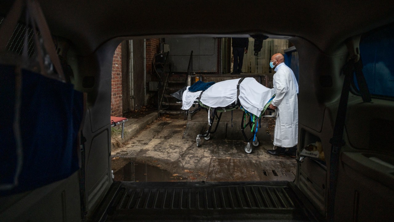 (FILES) In this file photo taken on December 24, 2020, Maryland Cremation Services transporter Reggie Elliott brings the remains of a Covid-19 victim to his van from the hospital's morgue in Baltimore, Maryland, during the Covid-19 pandemic. - America is about to cross one million deaths from Covid-19, a grim milestone that comes as cities like New York try to turn the page on the pandemic despite threats of another surge. "It's unfathomable," Diana Berrent, one of the first people in New York state to catch coronavirus, said of the toll that has far exceeded the highest estimates of epidemiologists at the outbreak in spring 2020. Then, New York City was the virus epicenter. Hospitals and morgues overflowed and empty streets rang to the sound of ambulance sirens as ex-president Donald Trump responded chaotically in Washington. (Photo by Andrew CABALLERO-REYNOLDS / AFP)