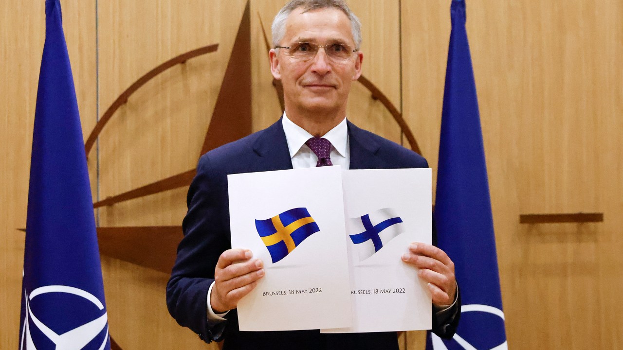 NATO Secretary-General Jens Stoltenberg poses with application documents presented by Finland's Ambassador to NATO Klaus Korhonen and Sweden's Ambassador to NATO Axel Wernhoff during a ceremony to mark Sweden's and Finland's application for membership in Brussels, on May 18, 2022. - Finland and Sweden submitted their applications for NATO membership on May 18, 2022 and consultations were underway between the Allies to lift Turkey's opposition to the integration of the two Nordic countries into the Alliance. (Photo by JOHANNA GERON / POOL / AFP)