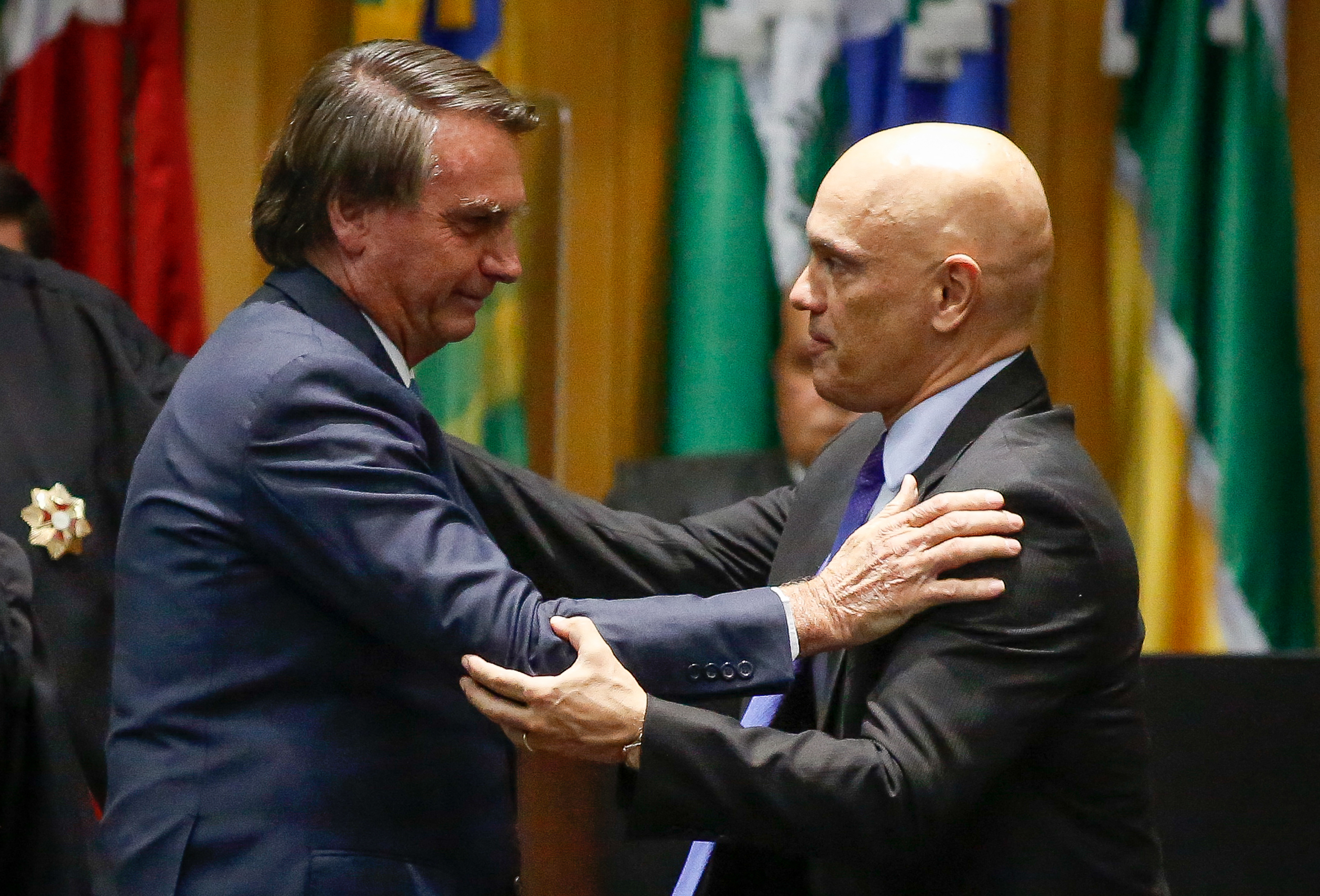 Brazil's President Jair Bolsonaro (L) greets Judge Alexandre de Moraes during an inauguration ceremony of new judges of the Superior Labor Court in Brasilia, on May 19, 2022. (Photo by Sergio Lima / AFP)