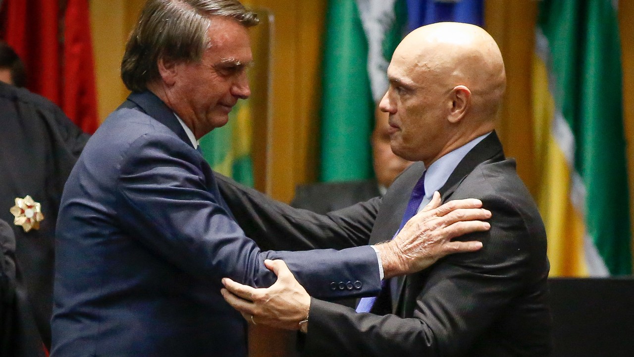 Brazil's President Jair Bolsonaro (L) greets Judge Alexandre de Moraes during an inauguration ceremony of new judges of the Superior Labor Court in Brasilia, on May 19, 2022. (Photo by Sergio Lima / AFP)