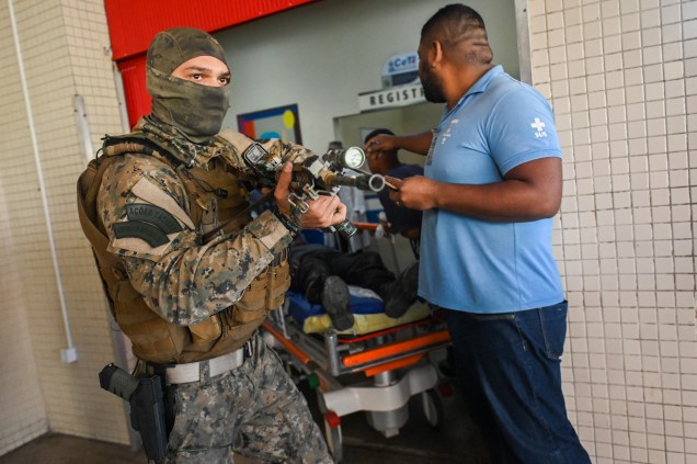 Um policial civil é transportado na maca ao chegar no Hospital Getúlio Vargas, após ser ferido durante operação na Vila Cruzeiro -