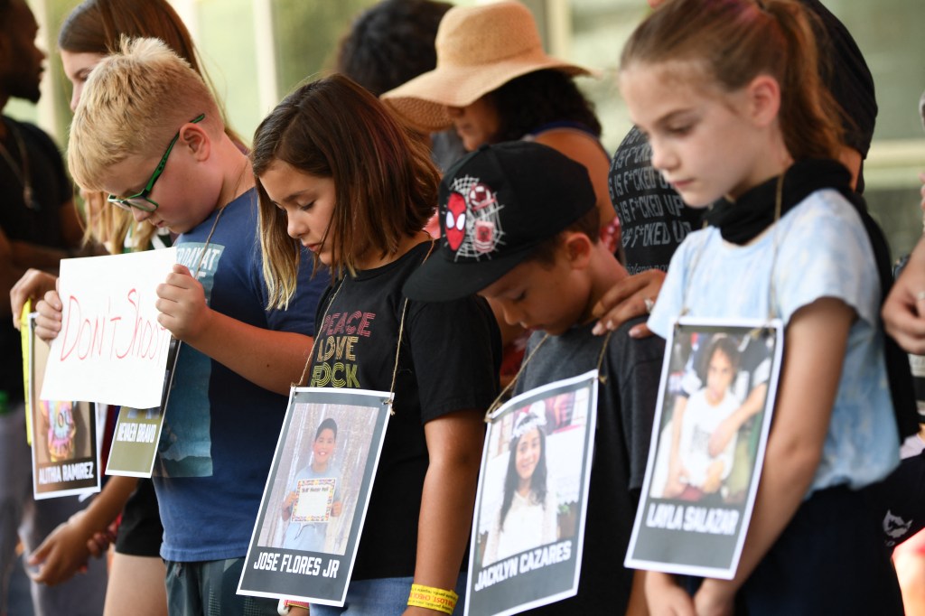 Children holding photos of victims of the Robb Elementary School shooting, participate in a minute of silence outside the National Rifle Association Annual Meeting at the George R. Brown Convention Center, on May 27, 2022, in Houston, Texas. - America's powerful National Rifle Association kicked off a major convention in Houston Friday, days after the horrific massacre of children at a Texas elementary school, but a string of high-profile no-shows underscored deep unease at the timing of the gun lobby event. (Photo by Patrick T. FALLON / AFP)