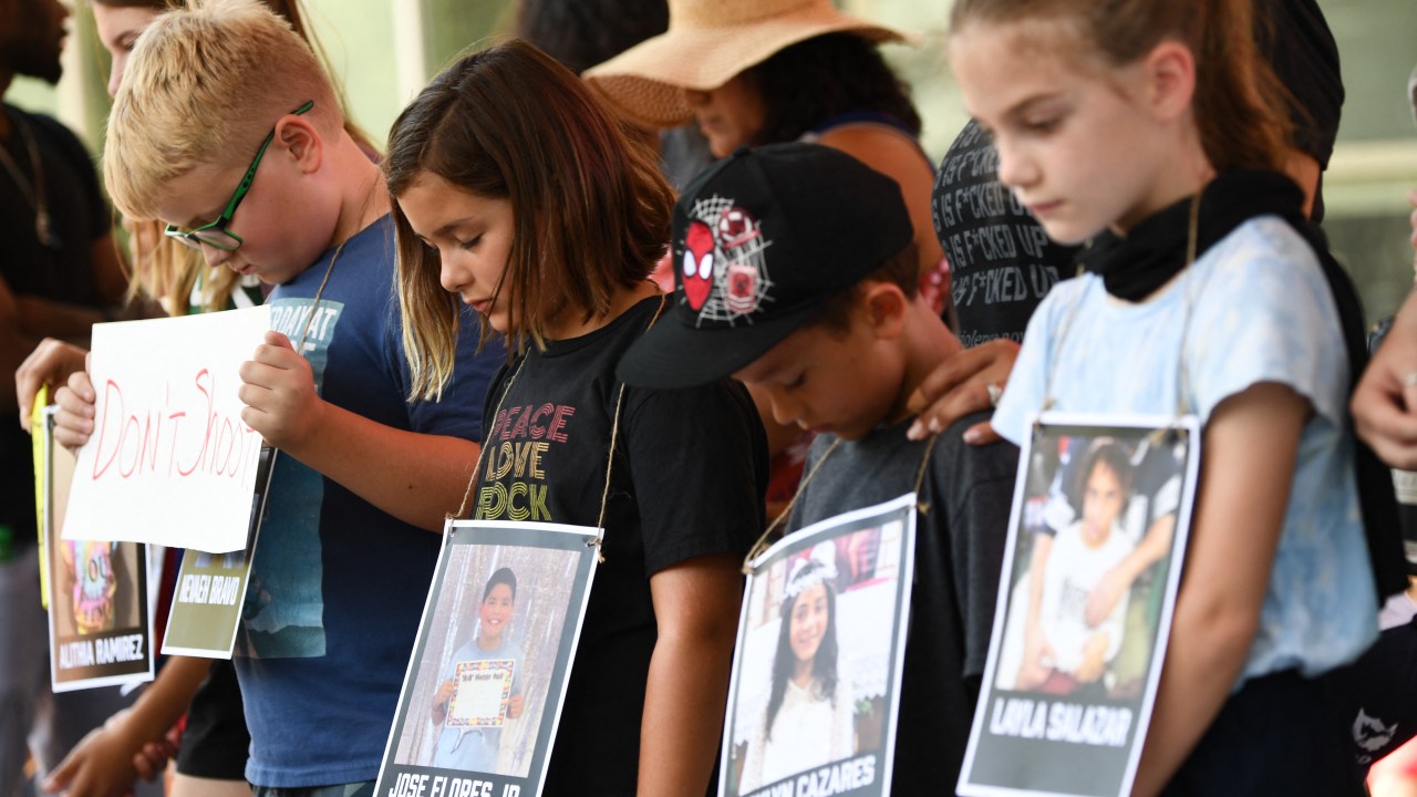 Children holding photos of victims of the Robb Elementary School shooting, participate in a minute of silence outside the National Rifle Association Annual Meeting at the George R. Brown Convention Center, on May 27, 2022, in Houston, Texas. - America's powerful National Rifle Association kicked off a major convention in Houston Friday, days after the horrific massacre of children at a Texas elementary school, but a string of high-profile no-shows underscored deep unease at the timing of the gun lobby event. (Photo by Patrick T. FALLON / AFP)